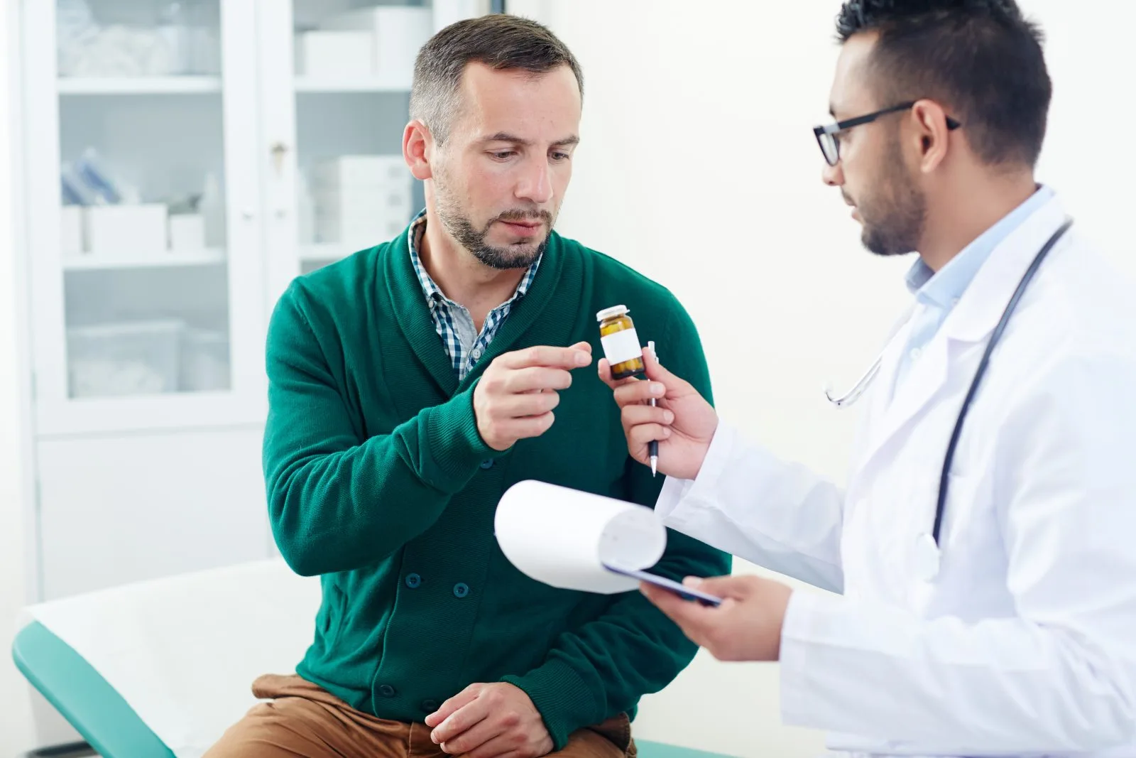 Pharmacist discussing a compounded medication bottle with a patient in a bright clinical setting